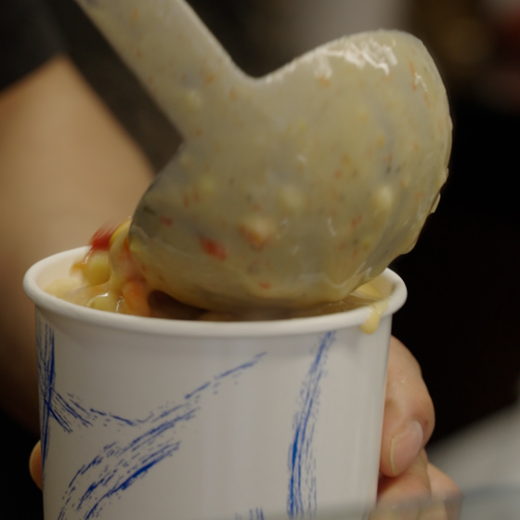 Soup ladled into a paper cup